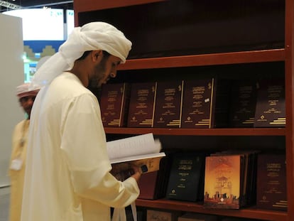 Un hombre lee un libro en la Feria del Libro de Emiratos &Aacute;rabes