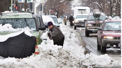 Una vecina de Capitol Hill trata de despejar su coche con una pala tras la nevada histórica del fin de semana que dejó entre 45 y 97 centímetros de espesor.