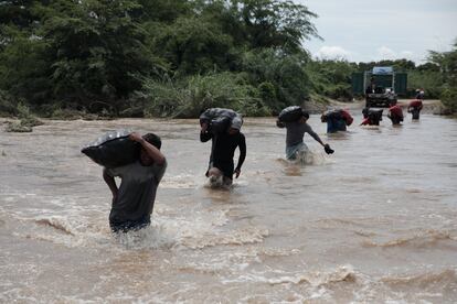 Un grupo de hombres cruza una inundación, en la región Piura, al norte del país. Esta fue una de las zonas más impactados por el inusual calentamiento del mar.