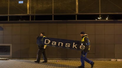 Dois operários retiram o cartaz do Danske Bank na filial de Tallin (Estônia), em 5 de outubro de 2019.