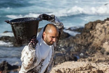 Workers cleaning the oil from El Cabrón beach.