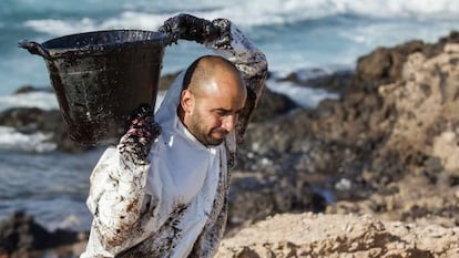 Workers cleaning the oil from El Cabrón beach.