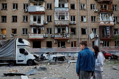 Una pareja observa los efectos del ataque ruso sobre un edificio en Kiev.