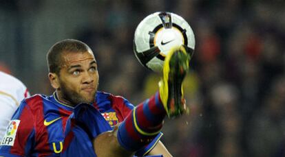 Dani Alves intenta controlar el balón.