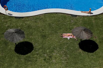 Dos mujeres toman el sol en una piscina en Tomares, Sevilla.