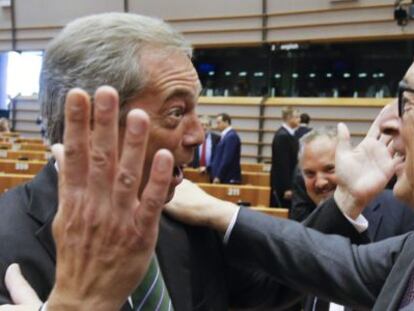 El presidente de la Comisión Europea, Jean-Claude Juncker (d), saluda al líder del Partido de la Independencia de Reino Unido (UKIP), Nigel Farage (i), al inicio de una sesión plenaria extraordinaria del Parlamento Europeo (PE).