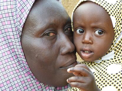 Raika Abadulaye abraza a su hija pequeña. Ella es beneficiaria de la iniciativa Escuela de Maridos en el distrito de Sona en Níger.