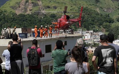 Moradores observam resgate de feridos nos desabamentos na comunidade de Muzema.