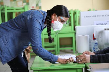 Verónica Mendoza, candidata de Juntos por el Perú toma tinte para su dedo antes de emitir su voto en un colegio electoral en Lima.