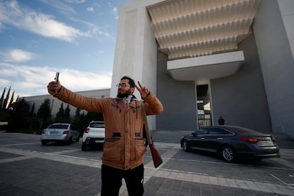 Un rebelde se hace fotos a las puertas del palacio presidencial de Damasco. 