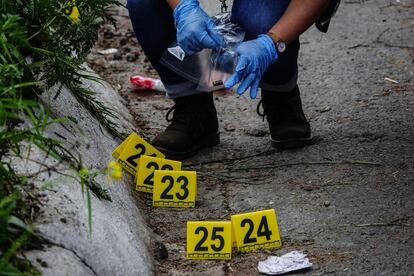 An expert collects the debris from the used ammunition after the shooting in the south of Mexico City. 