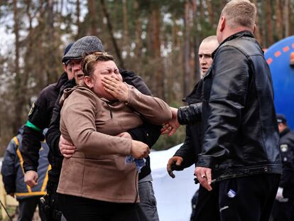 Una madre llora desconsolada ante la exhumación del cuerpo de su hijo, muerto en un ataque ruso a la estación de Buzova, en la región de Kiev, este domingo.