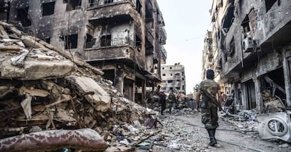 Un soldado de las tropas sirias camina entre las ruinas de Yarmuk. a tres kil&oacute;metros de Damasco.