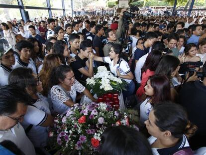 Amigos y compañeros de las víctimas en su funeral.