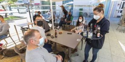 Una camarera sirve en una terraza del municipio de O Grove durante el primer fin de semana de apertura del cierre perimetral.