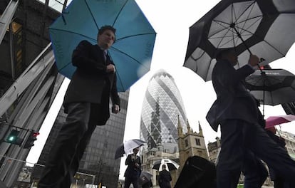 Trabajadores de la City de Londres cruzan frente al edificio diseñado por Norman Foster conocido como "The Gherkin" (El Pepinillo)