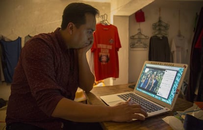 Jesús Ortiz looks at a photo of his family after being deported to Mexico.