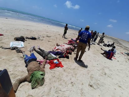 Trabalhadores da OIM e forças de segurança do Djibuti ao lado dos corpos dos migrantes que morreram na segunda-feira quando tentavam regressar ao continente africano.