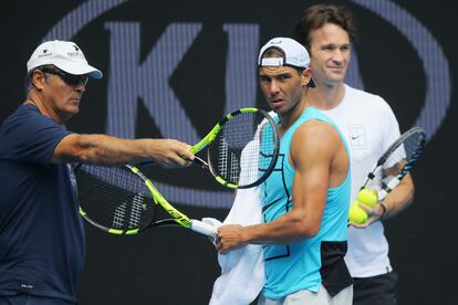 Rafa Nadal escucha a los entrenadores Tony Nadal y Carlos Moya durante una sesión de práctica antes del Abierto de Australia, el 15 de enero de 2017 en Melbourne Park.