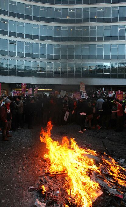 Hoguera y manifestantes en las inmediaciones del Partido Conservador de Reino Unido