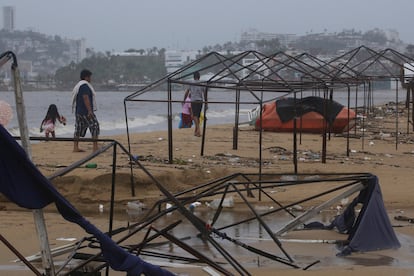 Guerrerenses caminan por una playa llena de escombros tras el paso del huracán John en Acapulco, la mañana del 24 de septiembre de 2024. 