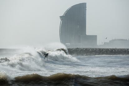 Un surfista aprofita el fort onatge a les platges de Barcelona. 