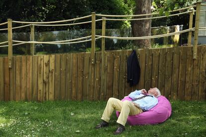 Un hombre echado en un cojín al sol en un jardín durante el Chelsea Flower Show en el Royal Hospital Chelsea, Londres. 19 de mayo de 2014.