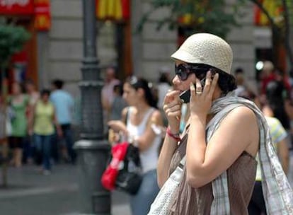 Una mujer habla por su móvil en una calle de Madrid.