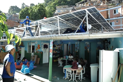 Workers with the nonprofit organization Revolusolar install solar panels on a nursery in the Chapeu Mangueira favela in Rio de Janeiro, Brazil, on Wednesday, March 1, 2023