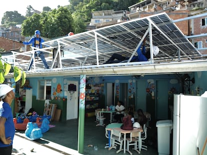 Workers with the nonprofit organization Revolusolar install solar panels on a nursery in the Chapeu Mangueira favela in Rio de Janeiro, Brazil, on Wednesday, March 1, 2023