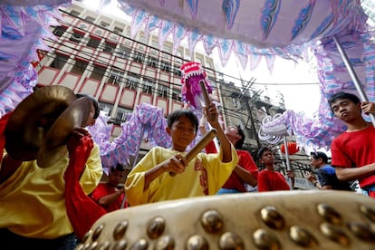 Ciudadanos filipino-chinos participan en las danzas del león y el dragón frente a una tienda en la víspera del Año Nuevo chino, el 4 de febrero de 2019, en el distrito de Chinatown de Manila, Filipinas.