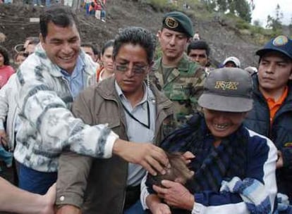 Rafael Correa acaricia a la hija de una campesina de la ciudad de Pingüe.