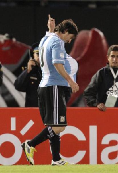 Lionel Messi celebra un gol en el estadio Monumental de Buenos Aires con un balón dentro de la camieseta.