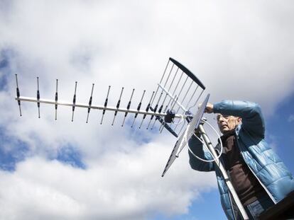 Un antenista cambia una antena y resintoniza los canales de TDT.