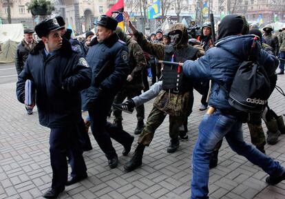 "Esta ley debe beneficiar a todos los que han participado en las protestas. Todos deben saber que están protegidos, que nadie los va a perseguir judicialmente", declaró anoche el líder del partido opositor Batkivshina (Patria), Arseni Yatseniuk, tras reunirse con al fiscal general de Ucrania, Víktor Pshonka. En la imagen, manifestantes antigubernamentales empujan a agentes de la policía en el centro de Kiev.