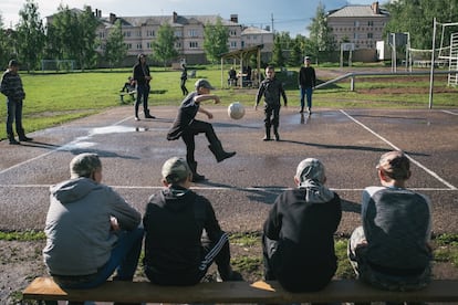 En la imagen, los niños juegan en un campo deportivo.