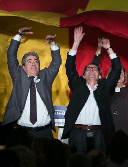 El candidato Francesc Homs (i) junto al presidente catalán en funciones, Artur Mas (d) aguantan una gran bandera catalana, en el mitin de final de campaña de  Democracia i Llibertat, celebrado en Barcelona