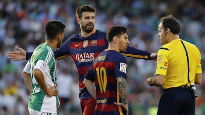 Piqué protesta a l'àrbitre Mateu Lahoz després de rebre una targeta groga, en presència de Leo Messi durant el partit contra el Betis.