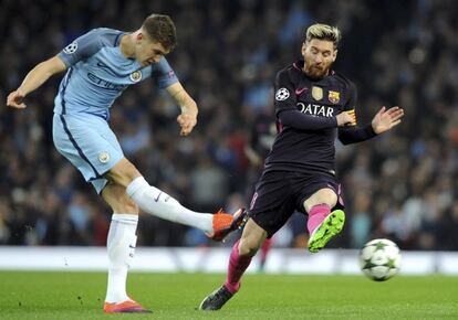 John Stones despeja un balón ante Lionel Messi.