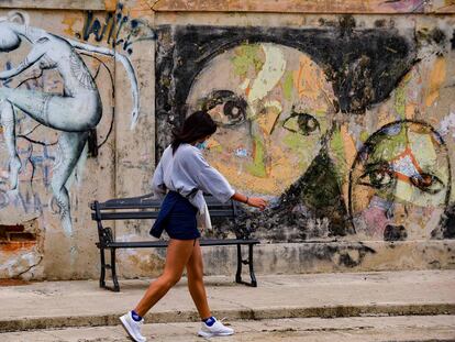 Una estudiante pasea delante de un grafitti en La Habana este 17 de noviembre.