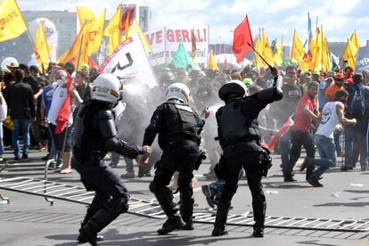 Antidisturbios frente a una multitud de manifestantes.