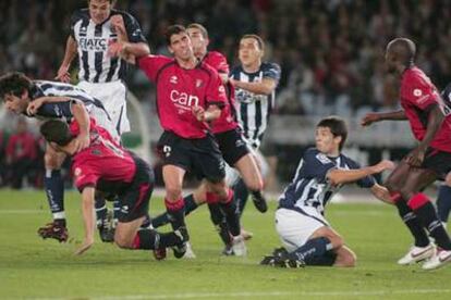 Jugadores de Osasuna y de la Real forcejean tras sacarse un córner favorable al equipo donostiarra.