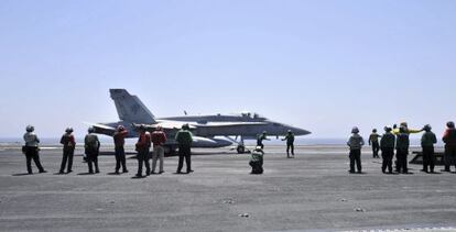 Membros da Marinha dos EUA guiando um avião Hornet F/A 18.