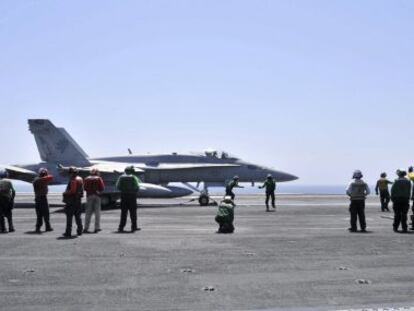 Miembros de la Marina de EE UU guiando a un avión Hornet F/A 18