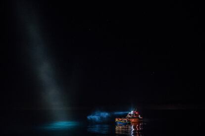 Los refugiados son escoltados al Topaz Responder en un barco de madera durante un rescate en el mar Mediterráneo, en Pozzollo (Italia). 