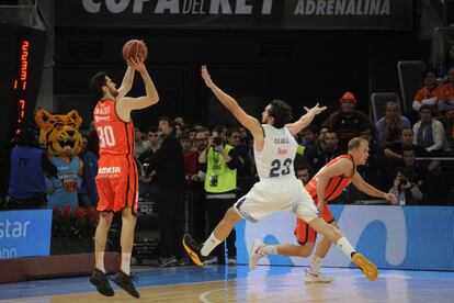 El jugador del Valencia, Sastre, intenta un triple ante la oposición del base del Real Madrid, Sergio Llull. 