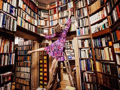 Una mujer busca un libro en una biblioteca.