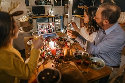 Una familia celebra una cena de Navidad por medio de una videollamada.