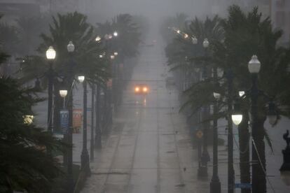 Un vehículo avanza entre la lluvia por las calles de Nueva Orleans.