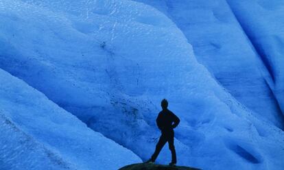 Un turista ante el hielo azul del glaciar Svartisen, al norte de Noruega.